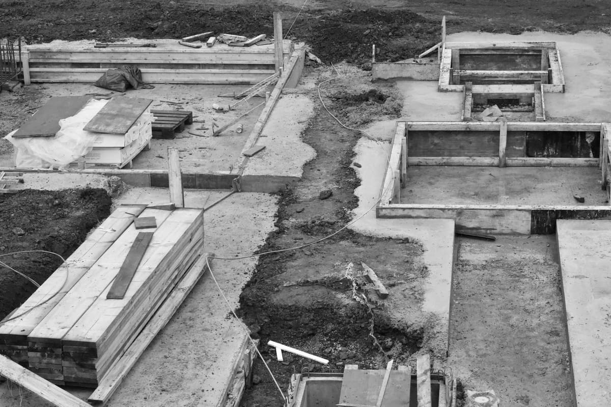 Ouvrier posant une dalle béton pour fondation d'abri de jardin
