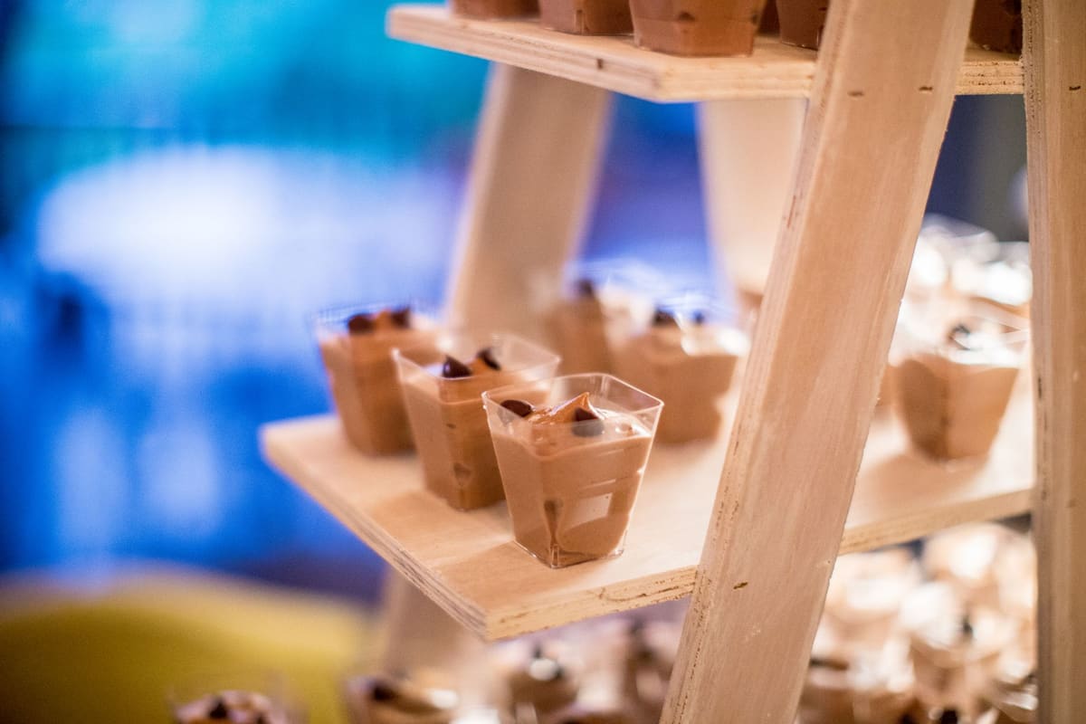 Recette de mousse au chocolat dressée dans des verrines sur un plan de travail crème